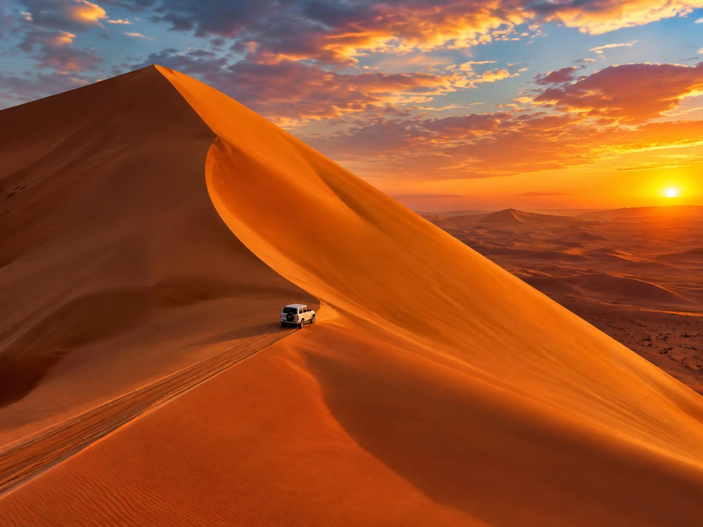 A four-wheel drive crossing the giant dunes of Liwa